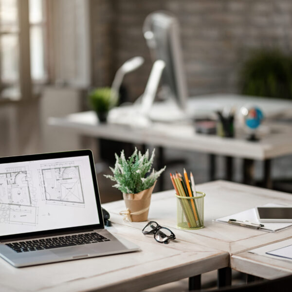 Blueprints on computer monitor at the desk in real estate office.